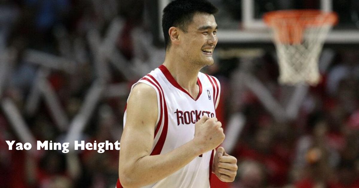 A smiling basketball player, Yao Ming, raises his hand, showcasing his impressive height and joyful demeanor.